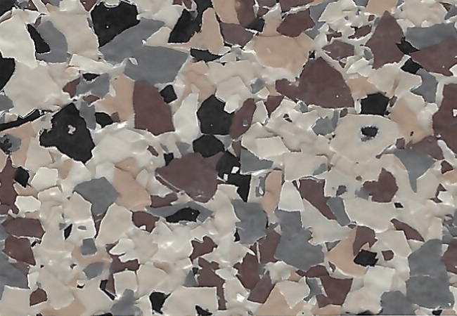 Close-up of terrazzo flooring with irregular beige, gray, brown, and black chips.